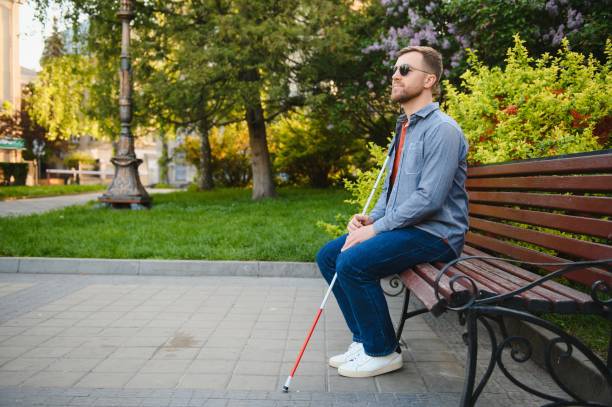istock Young handsome blinded man walking with stick in town 1455339282