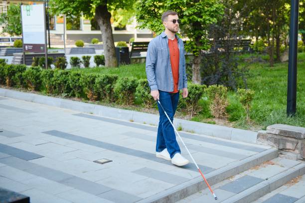 istock Blind Man Walking On Sidewalk Holding Stick 1455340500