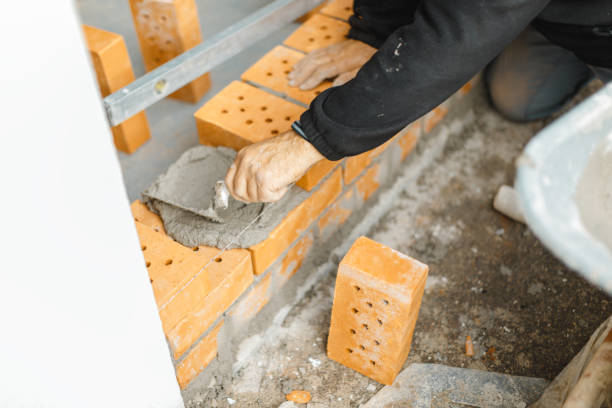 istock handyman coating the brickwall with concrete and trowel 1455340819