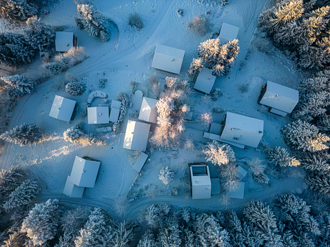 Aerial view of a snow-covered small village in the forest during winter