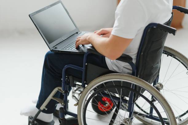 istock Modern young disabled man in wheelchair having video call 1455342397