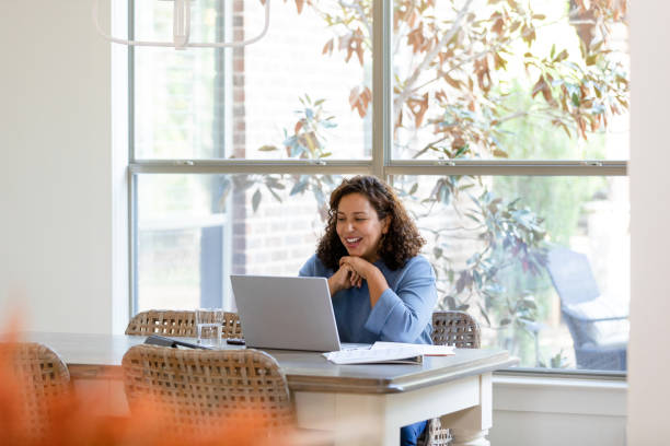 Mid adult woman talks during a virtual meeting stock photo