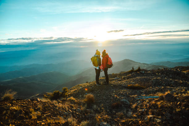 istock Two female hikers reaching the mountain peak and enjoying the view 1455346178