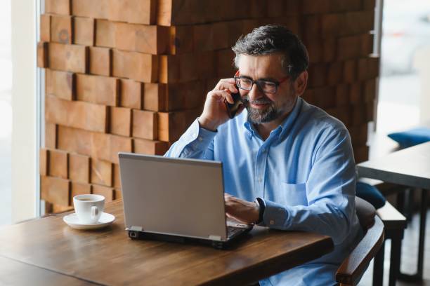 istock Senior male freelancer working on laptop in cafe. remote work concept. 1455346886