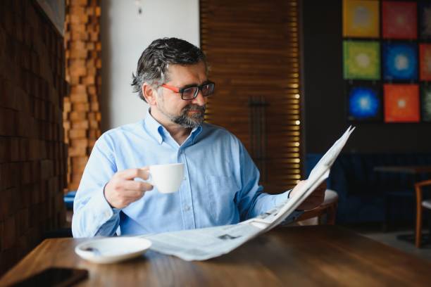 istock Business man reading a newspaper, cafe backgrounds 1455347050