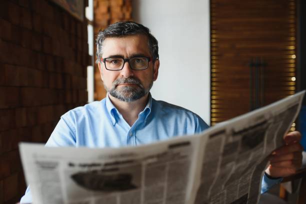 istock coffee break. man drinking coffee and reading newspaper in cafe bar 1455347076