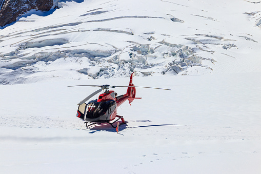 Red helicopter landed at Jungfrau mountain in Bernese Oberland, Switzerland