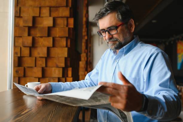 istock coffee break. man drinking coffee and reading newspaper in cafe bar 1455349591