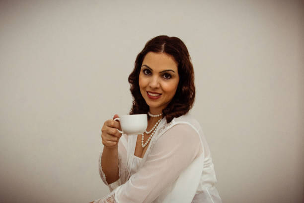 Woman looking at câmera and holding a cup
