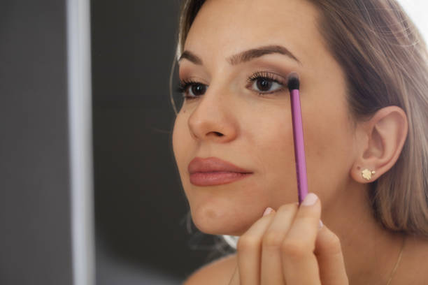 istock Woman Applying Eye Makeup with Brush 1455355552