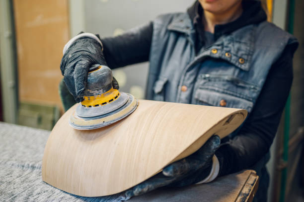 istock Woman carpenter using an electric sander in a workshop or factory 1455359707