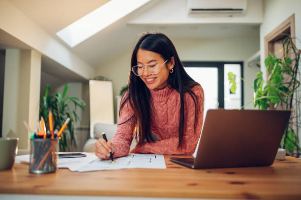 istock Vietnamese Asian woman using a laptop in her home office 1455359769