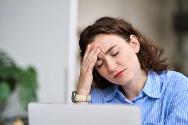 istock Tired young business woman touching head feeling headache fatigue at work. 1455362918