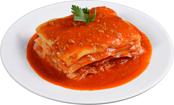 Meat lasagna with tomato sauce in white plate isolated on white background. stock photo