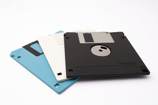 Retro vintage floppy disk diskettes on white background, old time computer storage equipment hardware