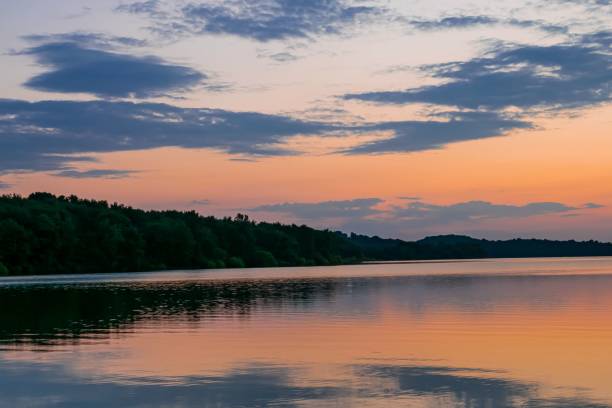 istock Beautiful shot of trees and clouds reflected on a river during the sunset 1455365102