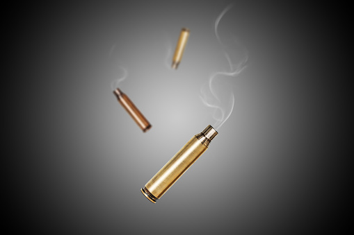 Smoking bullet assault rifle 5.56 casing shell fired out of a assault rifle falling down