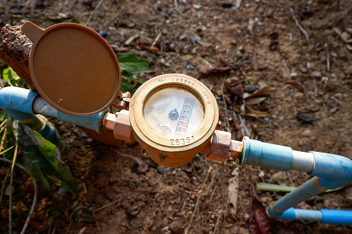 water meter on water pipe pvc on the ground, old water meter for check household water usage estimates in the village