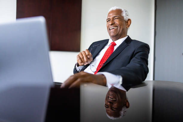 starszy czarnoskóry biznesmen korzystający z laptopa w sali konferencyjnej - thinking business ceo board room zdjęcia i obrazy z banku zdjęć