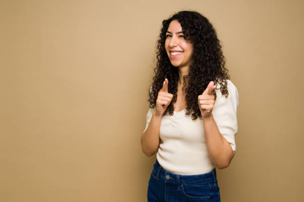istock Excited young woman having fun pointing with her fingers 1455374691