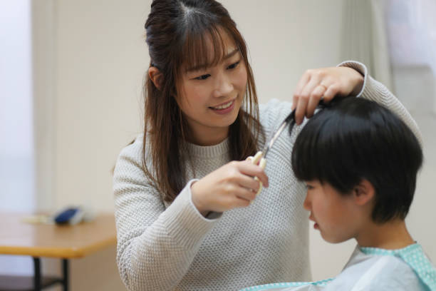 istock mother cutting child's hair 1455375007