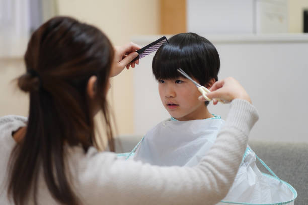 istock mother cutting child's hair 1455375020