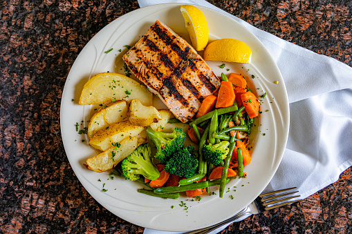 Grilled salmon with sauce and herbs served at restaurant