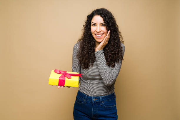 istock Excited hispanic woman holding a birthday present 1455376613