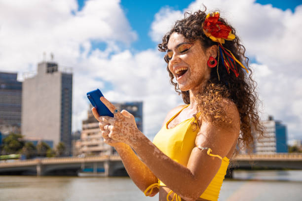 young woman sending message online by smartphone - rio carnival imagens e fotografias de stock