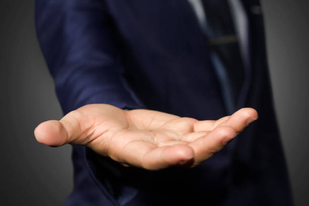 A businessman empty hand with black background, take my hand.