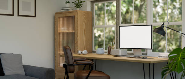istock Minimal home working room with PC computer mockup on wood table against the window 1455383954