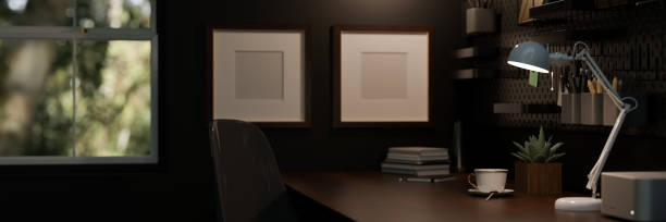 istock Modern dark home working space with copy space on wooden desk, lights from table lamp 1455383956
