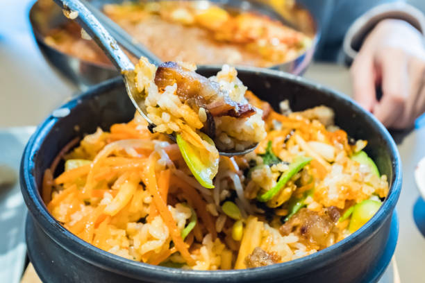 Dolsot bibimbap - Korean mixed rice, Include steamed rice, vegetables, pork and fried egg on top, served in a hot stone pot, Dolsot means stone pot in Korean.