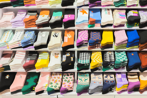 Multi colored socks stacked on shelves in the store, Socks with various patterns