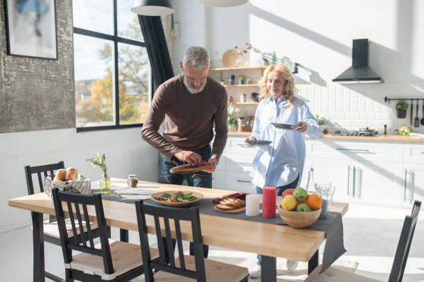 istock Man and woman serving the table for dinner 1455387100