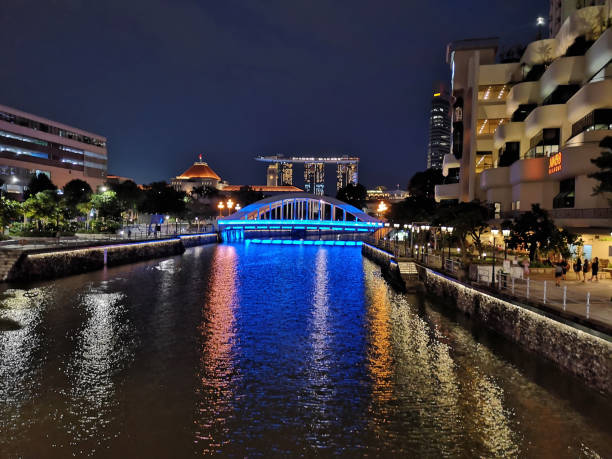 The Singapore river and Elgin Bridge by night in downtown Singapore.