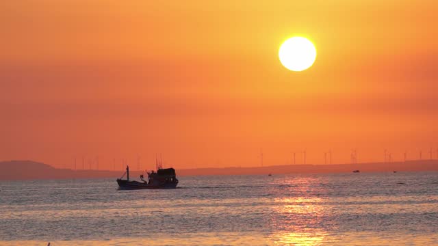 Sunset landscape when fishing boat out to sea to harvest fish end the day.