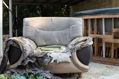a badly damaged sofa in the outdoor at horizontal composition