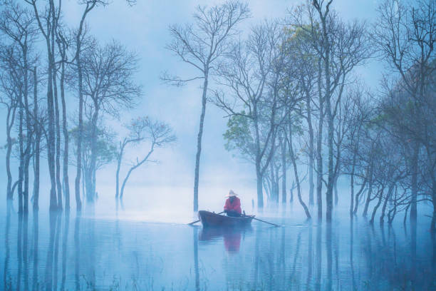 Fisherman in Tuyen Lam lake in a foggy morning, Da Lat city, Lam Dong province, central high lands Vietnam