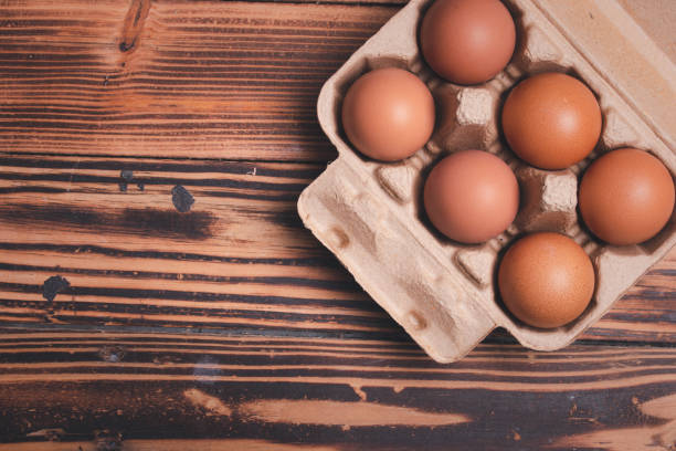 istock Fresh chicken eggs in cardboard boxes on wooden background 1455396307