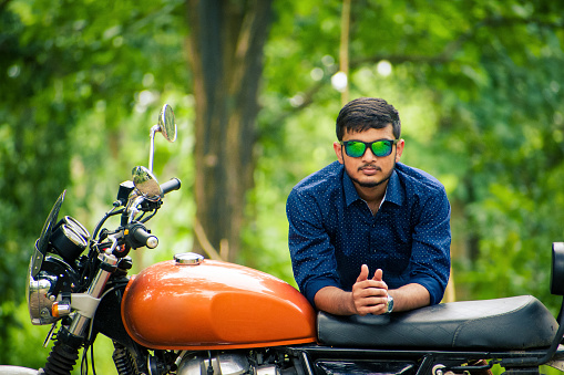 Handsome model posing on bike, with beautiful forest background.