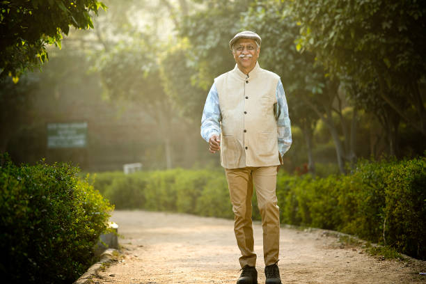 istock Smiling senior man with walking at park 1455404931