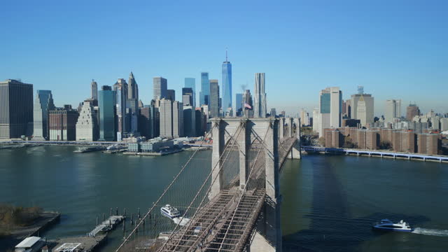 Amazing cinematic shot of cityscape with downtown skyscrapers on sunny day. Brooklyn Bridge and Lower Manhattan. New York City, USA