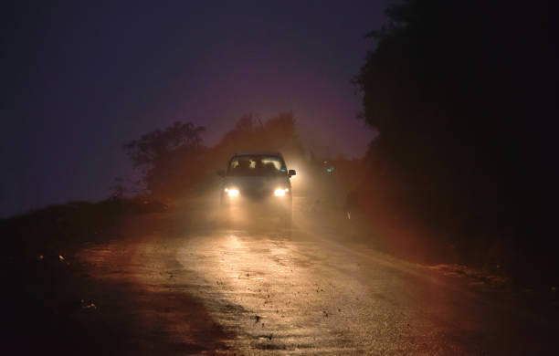 istock A car with headlights on moving in the dark. 1455409010