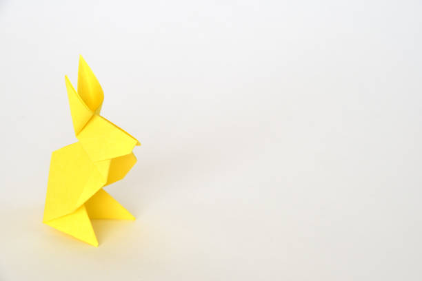 istock Yellow origami paper rabbit on white background. 1455411000
