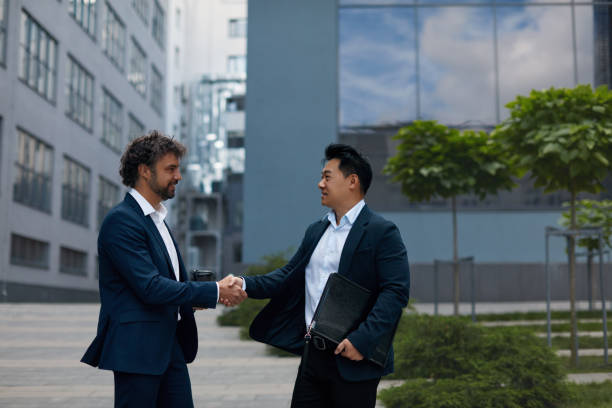 istock Lucky Multicultural Partners Shaking Hands on Meeting in City 1455414515