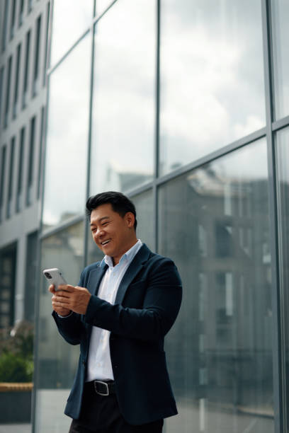 istock Asian Business Man Using Phone Near Office During Break 1455414533