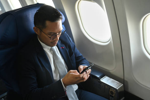 istock Confident businessman passenger checking news on smart phone, using wireless connection on board during flight. 1455416158
