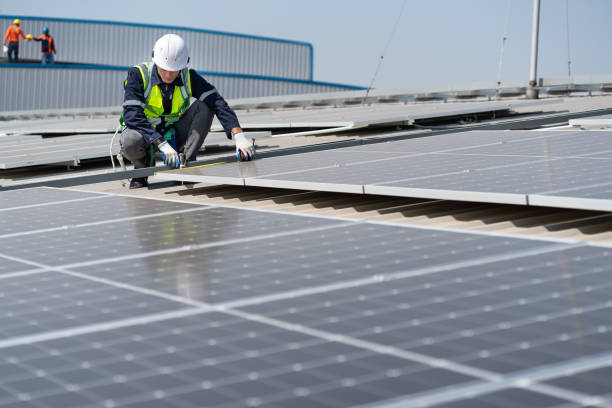 istock Caucasian engineer man use electric screwdriver working with solar panel on roof factory 1455418670