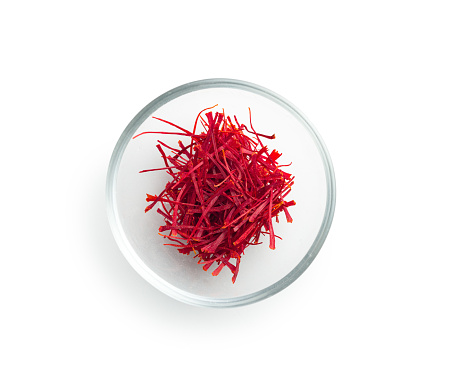 Dried saffron spice in bowl isolated on the white background.